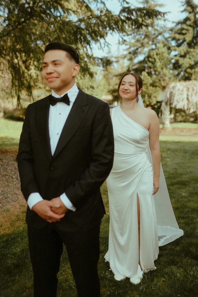 a groom waiting for his bride during the first look as she approaches