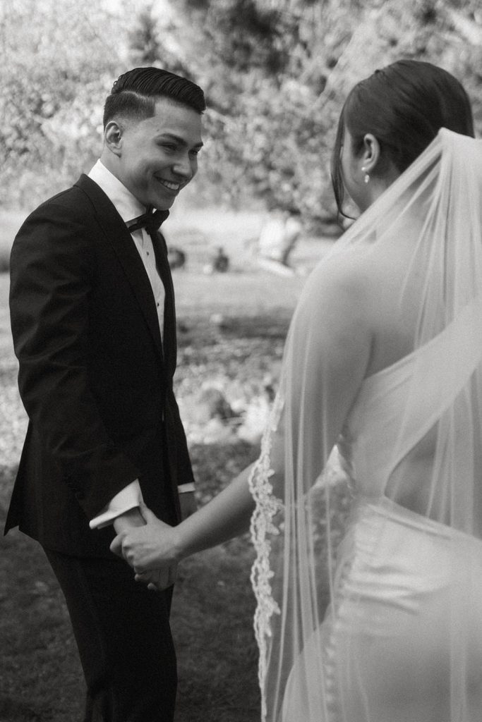 candid smile of a groom while looking at his bride for the first time