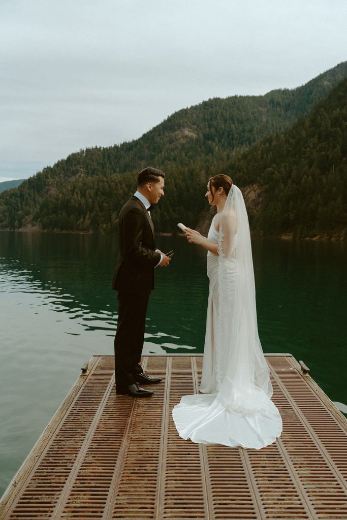 a bride reading her vows to her husband at lake crescent