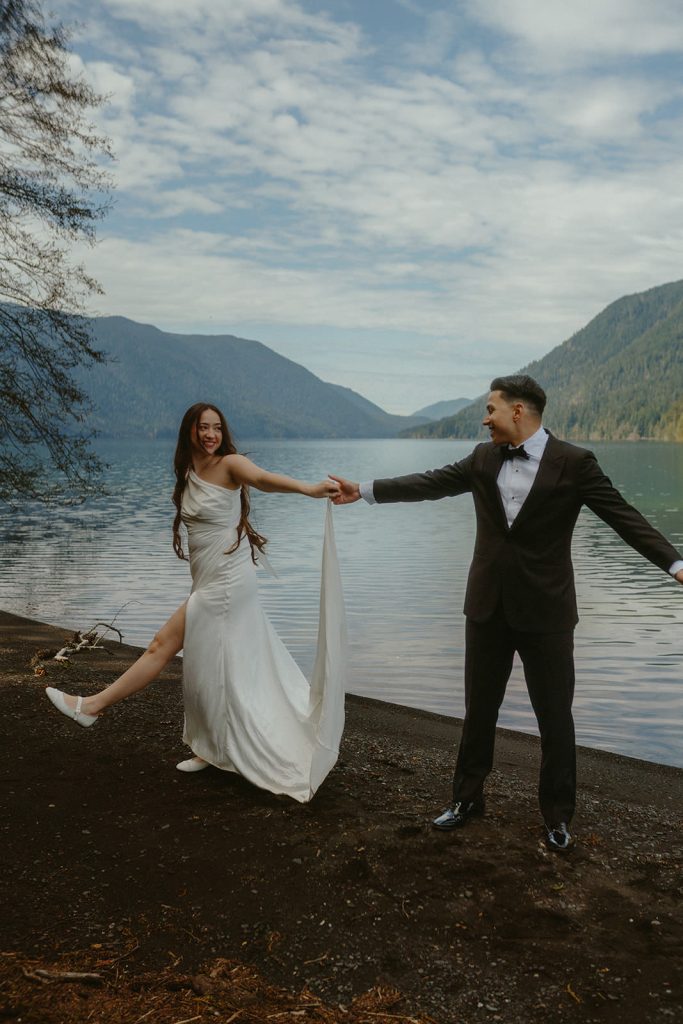 a groom and a bride walking along Lake Crescent during their elopement